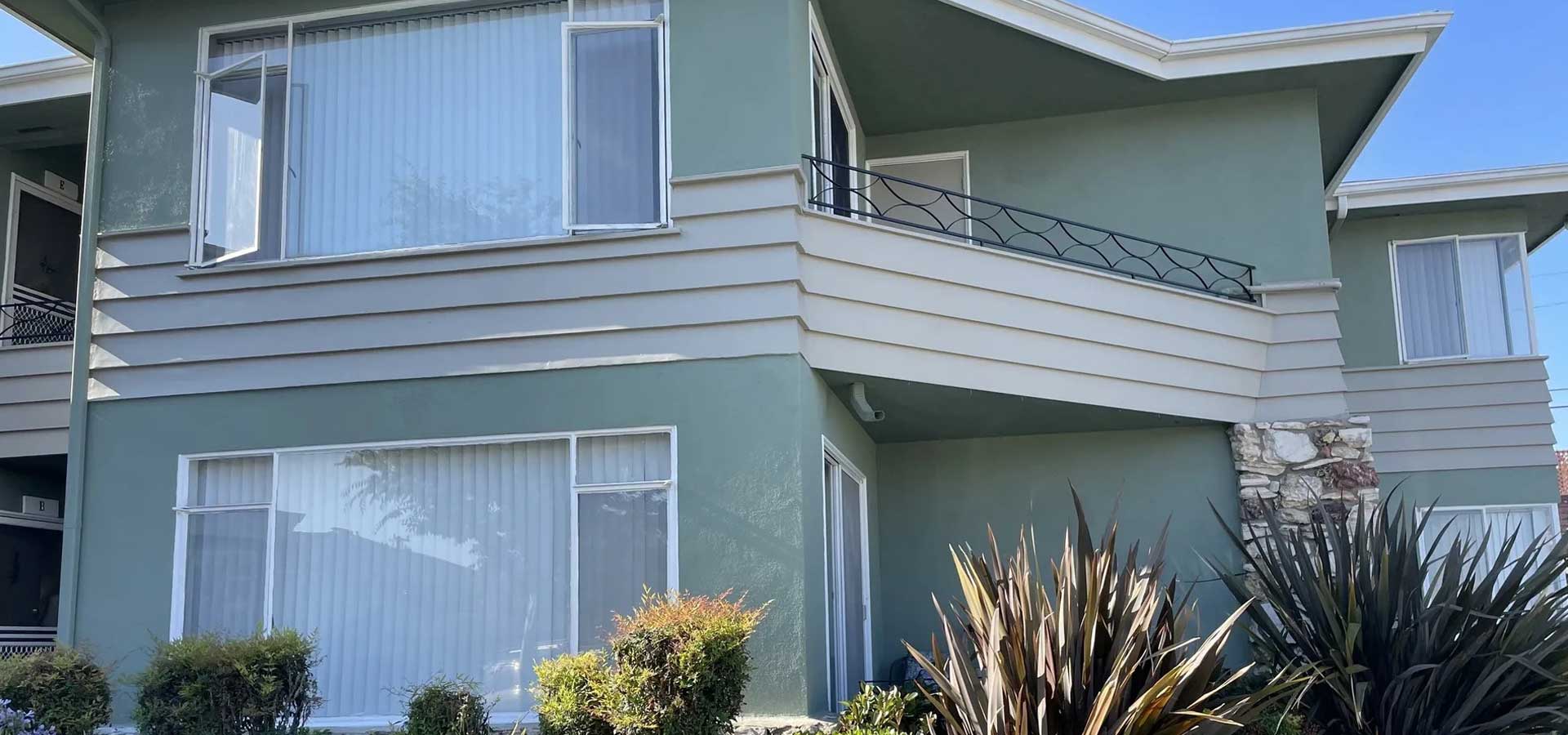 a Los Angeles house with a balcony and a window view